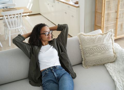 Client relaxing on the couch in a bright, freshly cleaned living room